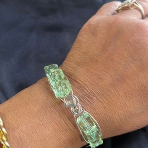 It’s a cute little cube shaped, lite green bracelet .